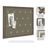 Green pinboard with a repeating light botanical print pattern, framed in medium brown wood, shown with two black-and-white photos pinned on it.