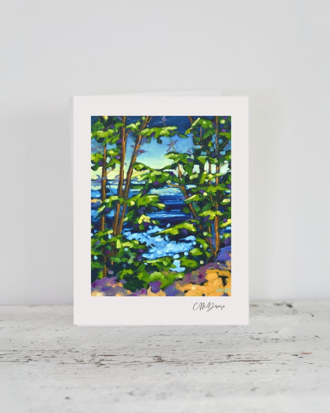 Notecard 'Waves Against the Lapse of Time' leaning on a natural wood table surface with ocean waves artwork visible