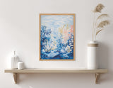 Framed print of an underwater landscape with blue, white, and pink coral and plants, hung above a simple wooden shelf displaying white vases and dried grass.