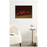 Painting of a cluster of bright red strawberries on a dark brown background with a simple frame, hung on a white wall above a small round brass side table.