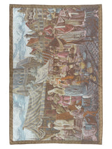 1990s Belgium tapestry showing a medieval market scene with vendors, townspeople in colorful period dress, and stone buildings under a cloudy sky, bordered by an ornate frame.