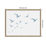 Framed artwork showing a flock of blue seagulls in various flying poses against a white background, with a light wood frame and dimensions labeled.