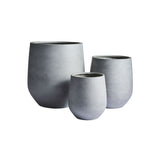 Three matte gray rounded planters of varying sizes with smooth, slightly tapered sides and open tops, arranged in a grouped composition.