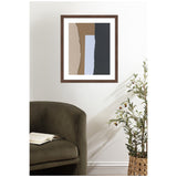 Framed abstract wall art with vertical torn paper strips in beige, brown, light blue, and dark gray, hanging above an olive-green chair and next to a potted plant.