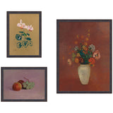 Three framed prints featuring a pink cyclamen on tan background, a still life of apples and grapes on purple, and a colorful bouquet in a pale vase on reddish-brown background.
