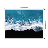 Aerial view of white ocean waves crashing against a black sandy beach with deep blue water and foamy surf, framed with labeled outer dimensions 42 by 32 inches.