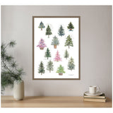 Framed canvas wall art depicting 12 small stylized holiday trees in varied green and pink hues on a white background, displayed above a wooden shelf with a vase and cup.