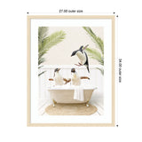 Three penguins are in and around a vintage clawfoot bathtub filled with bubbles, surrounded by two tall green palm leaves against a white wall backdrop.