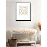 Abstract beige and white organic shapes in a square print framed in black, hanging above a white bench draped with a soft cream fur throw in a minimalist room.