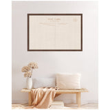 Large rectangular pinboard with vintage postcard linen fabric framed in dark wood, displayed on a light wall above a wooden bench with neutral pillows and dried flowers.