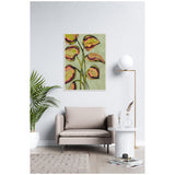 Framed canvas artwork of stylized foliage with pink, yellow, and green leaves on a muted green background, hanging above a beige armchair in a minimalist living room.