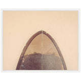 Top view of a minimalist surfboard nose with worn brown upper surface and sharp pointed shape contrasted against a peach background within a white frame.