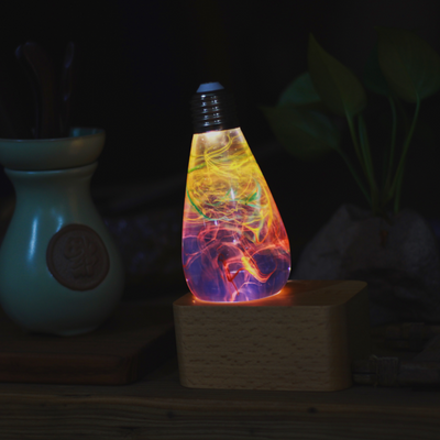 Three handcrafted resin LED light bulbs in a bundle, showing unique color patterns and resin designs