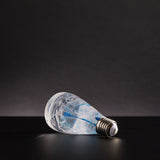 EP Light Blue-Drop Resin LED Bulb handcrafted with eco-friendly resin, shown with wooden base options