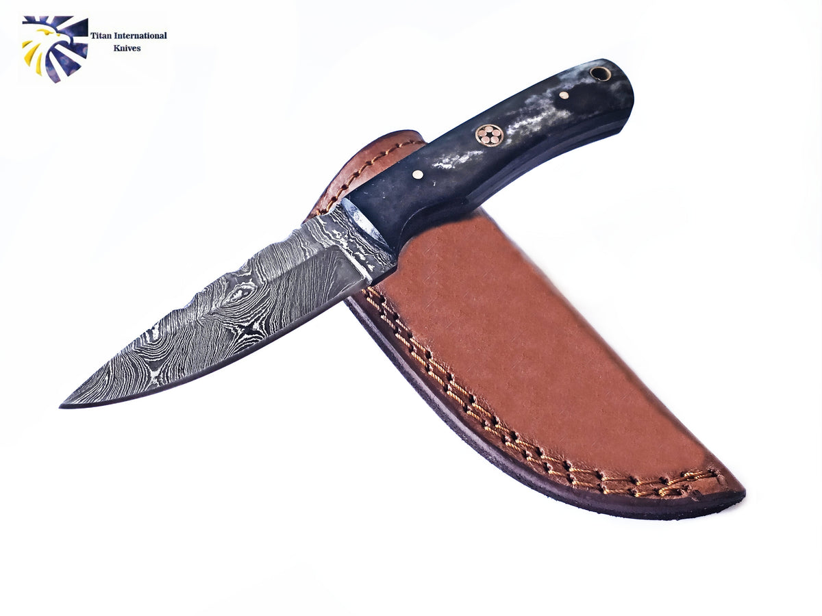 Dyed Bone Handle Titan International Knives Damascus Steel Skinning TD-213 lying on a wooden surface