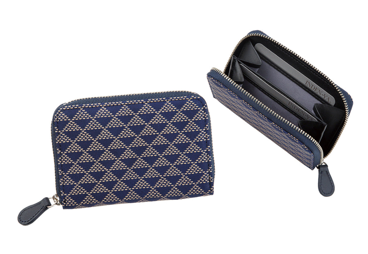Navy blue coin purse with beige geometric UROKO pattern, shown closed and open revealing black interior compartments and a zipper closure.