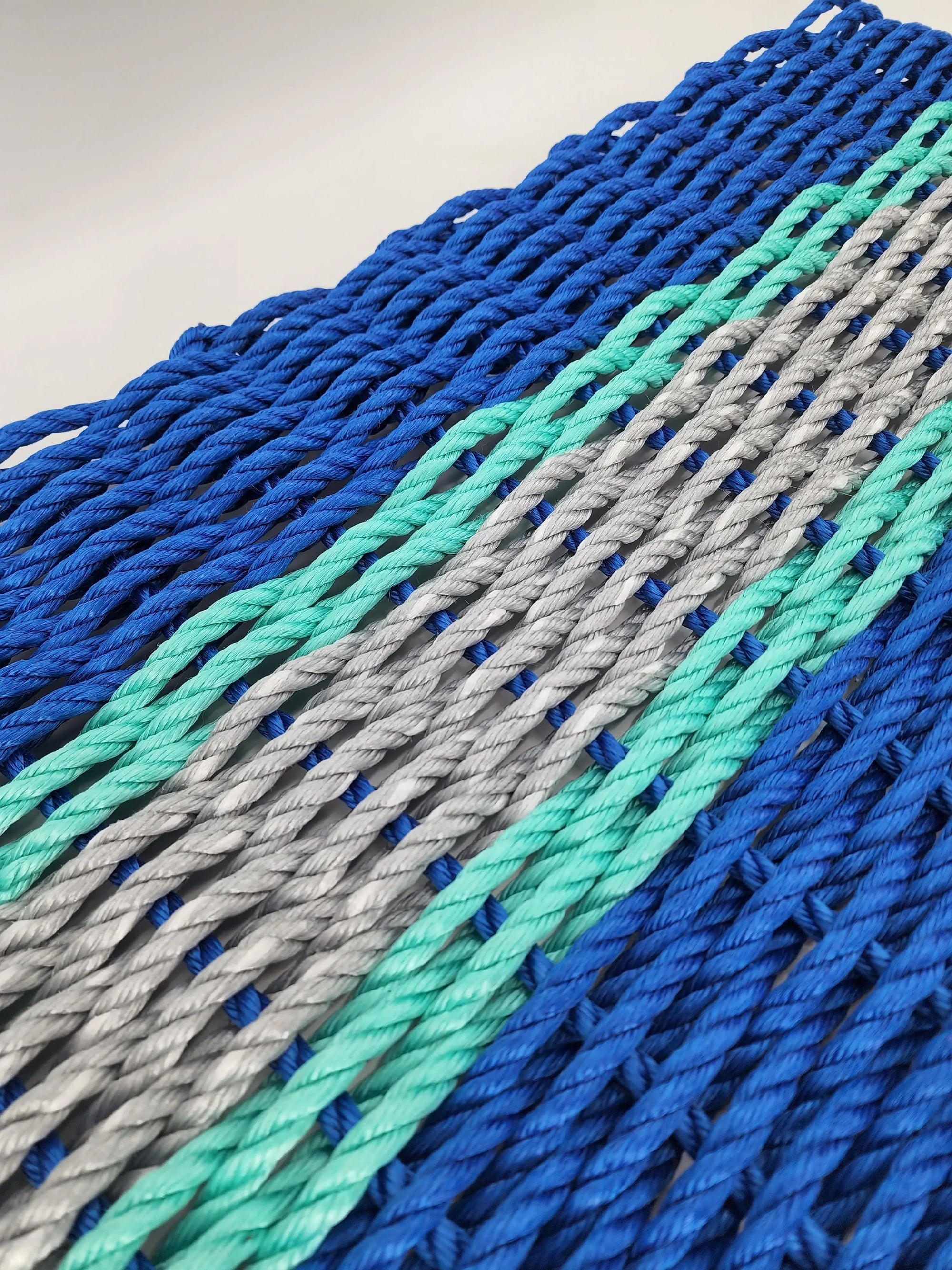 Handmade lobster rope door mat in blue, light gray, and teal accents
