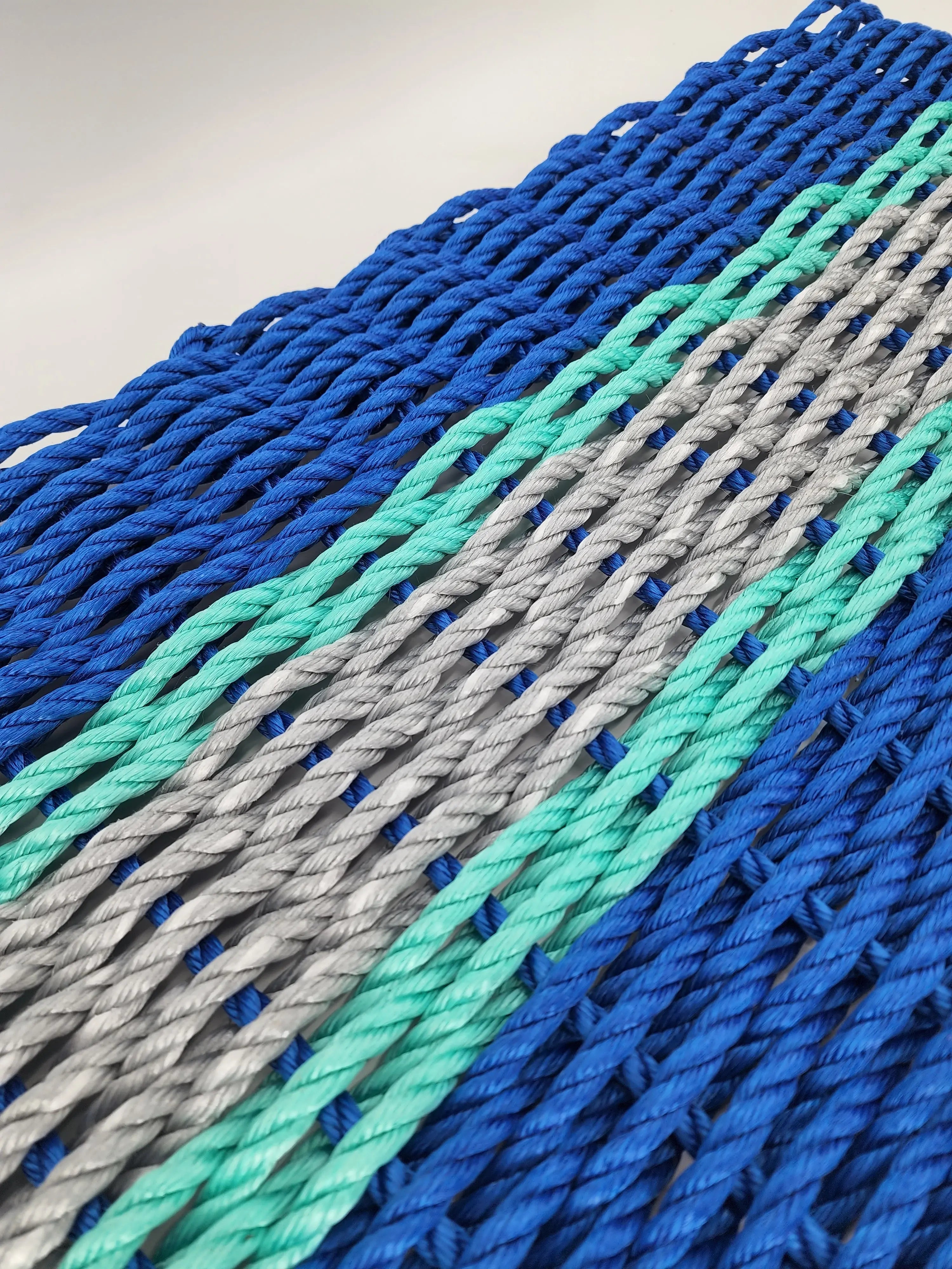 Handmade lobster rope door mat in blue, light gray, and teal accents