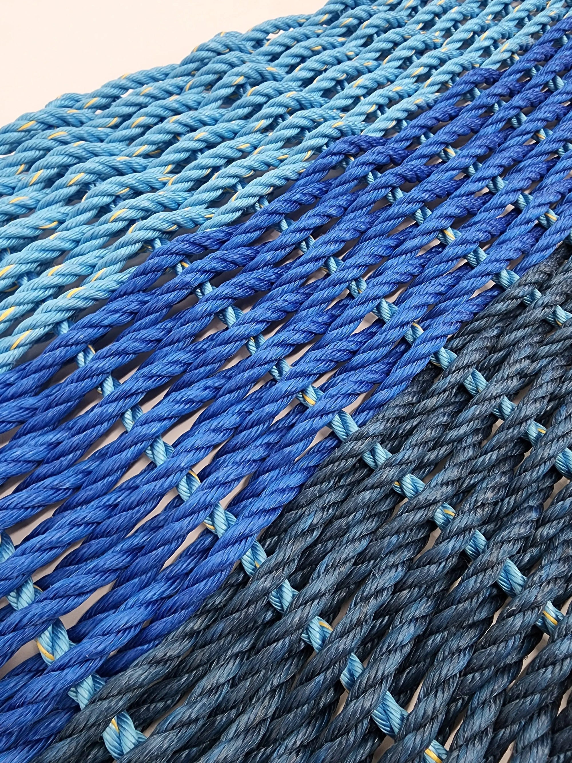 Handmade lobster rope mat in navy, royal, and light blue ombre colors