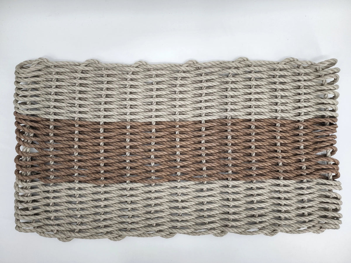 Handmade lobster rope mat in tan and brown colors, displayed on wooden floor