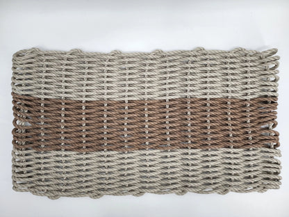 Handmade lobster rope mat in tan and brown colors, displayed on wooden floor