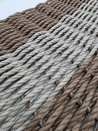 Handmade brown and tan lobster rope mat on wooden floor
