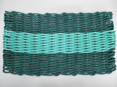 Hunter green and teal handmade lobster rope mat on wooden floor