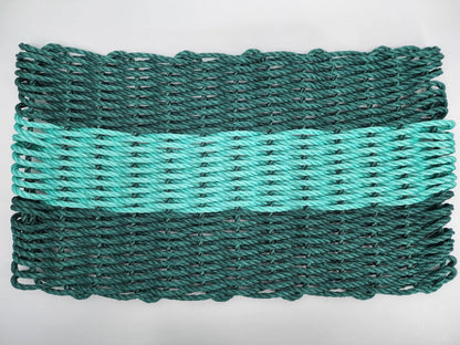 Hunter green and teal handmade lobster rope mat on wooden floor