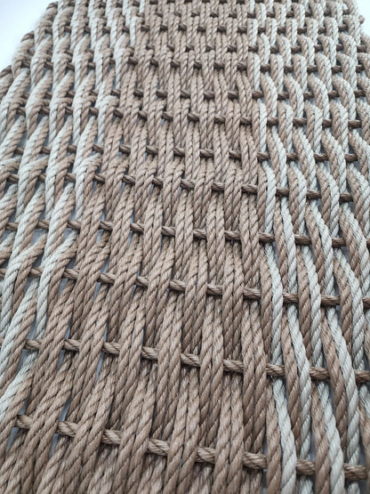 Large brown and tan double weave lobster rope mat on wooden porch