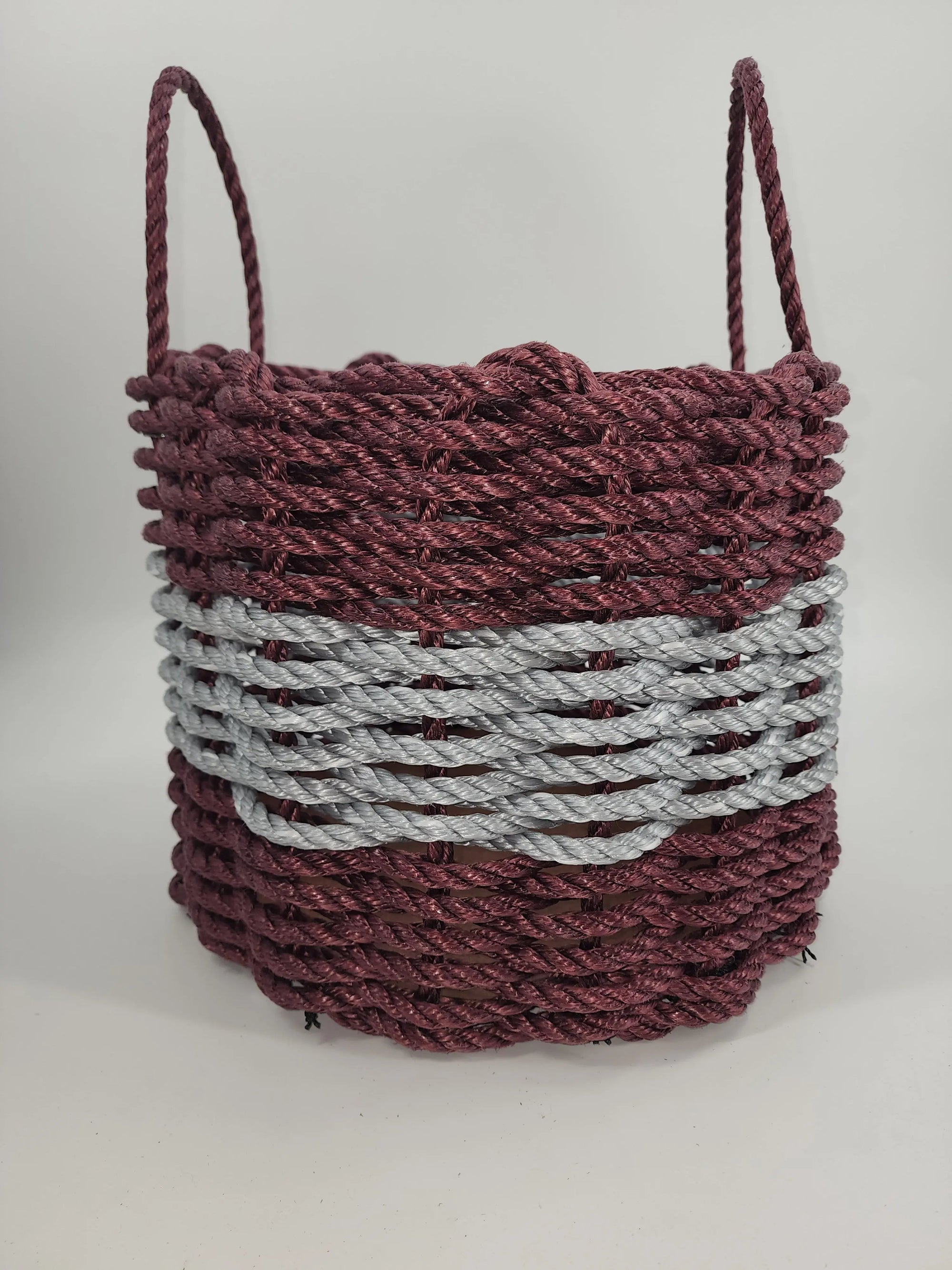 Handmade storage basket woven from burgundy and light gray Maine lobster rope