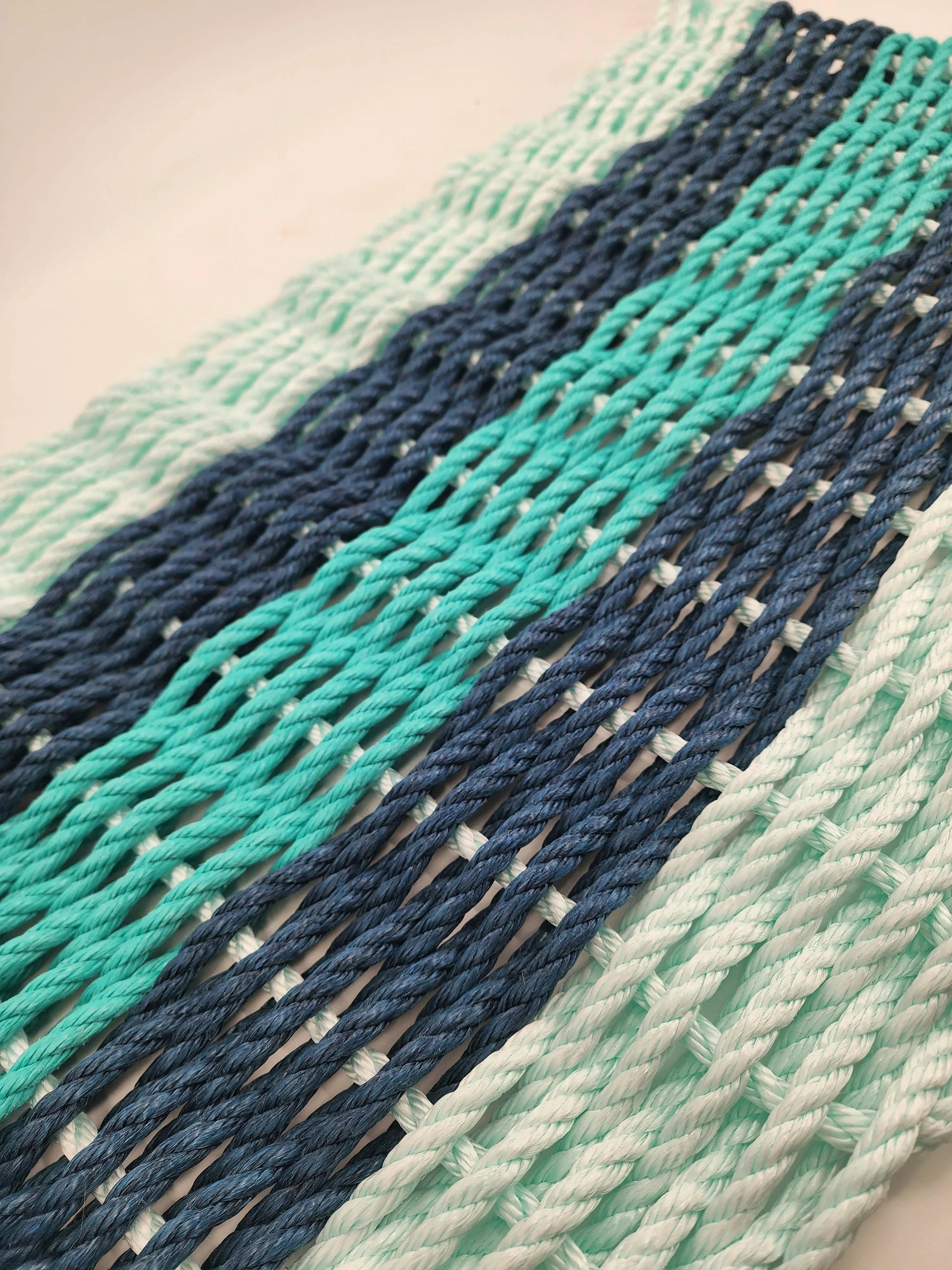 Seafoam, navy, and teal striped handmade rope mat made with lobster rope