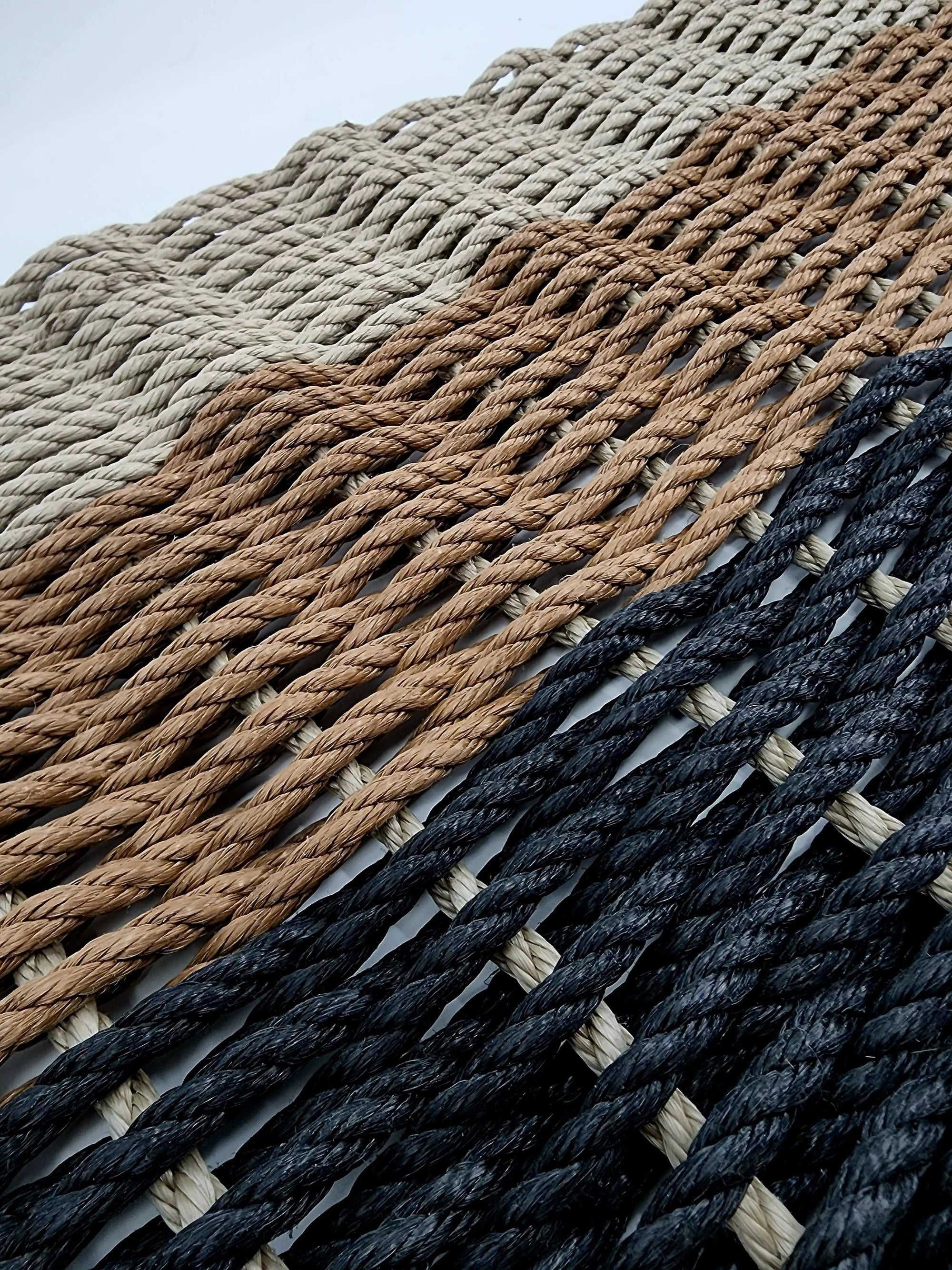 Handmade ombre rope mat in black, brown, and tan made with lobster rope