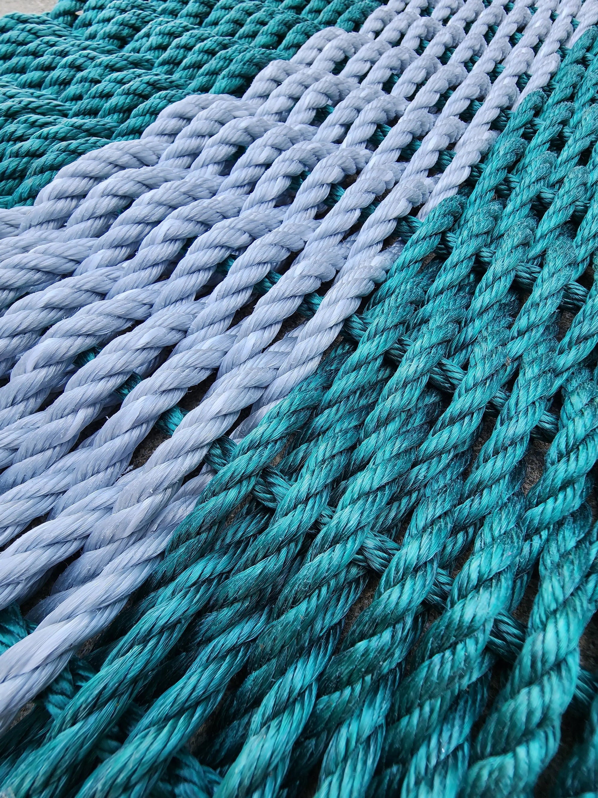 Handcrafted rope mat made with lobster rope in hunter green and light gray, sized 31 x 18 inches