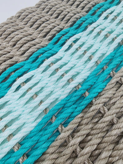 Handmade lobster rope door mat in tan with seafoam and navy blue accent colors
