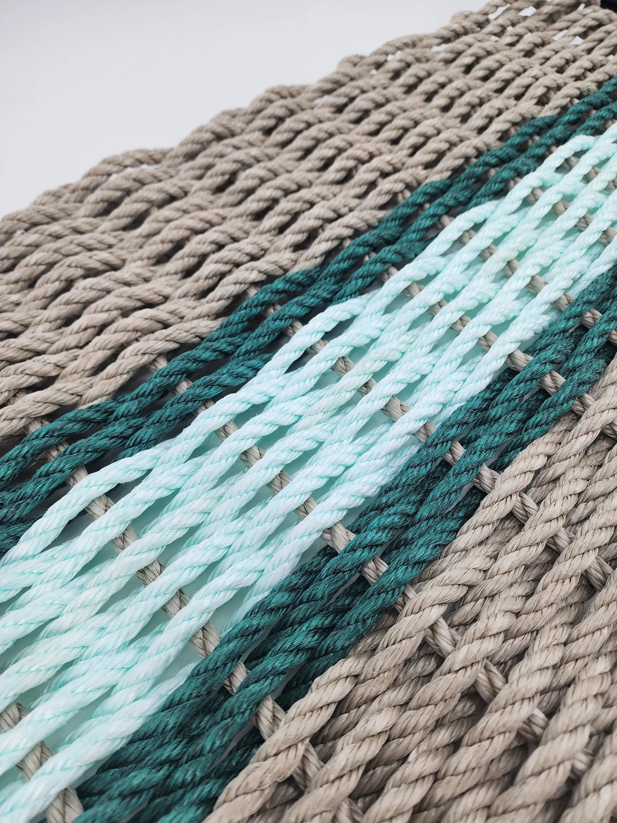 Handmade lobster rope door mat in tan with seafoam and navy blue accent colors