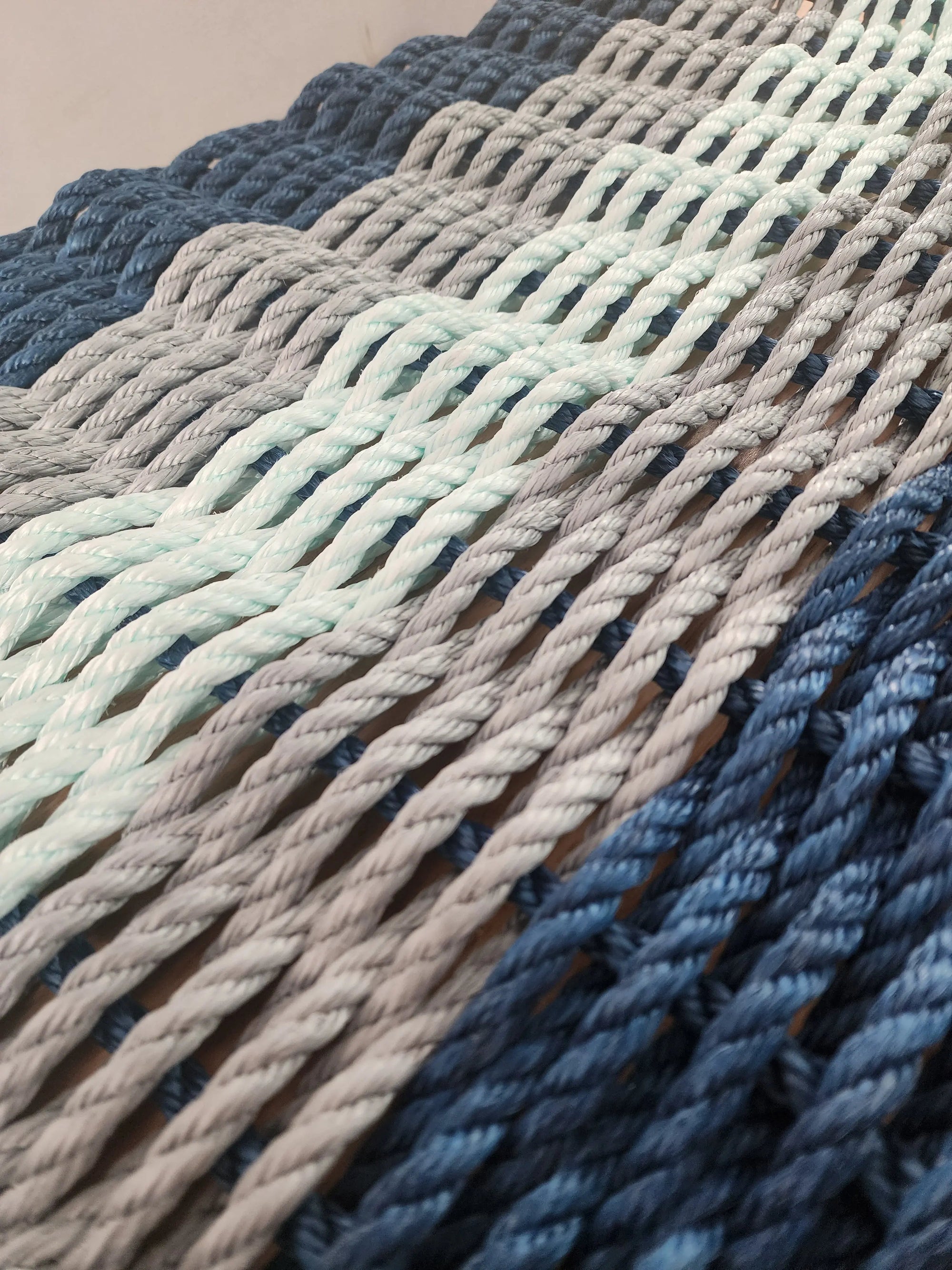 Five Stripe Rope Mat made with Lobster Rope in navy, light gray, and seafoam colors