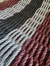 5 Stripe Lobster Rope Mat in Burgundy, Light Gray, and Black laid out on floor