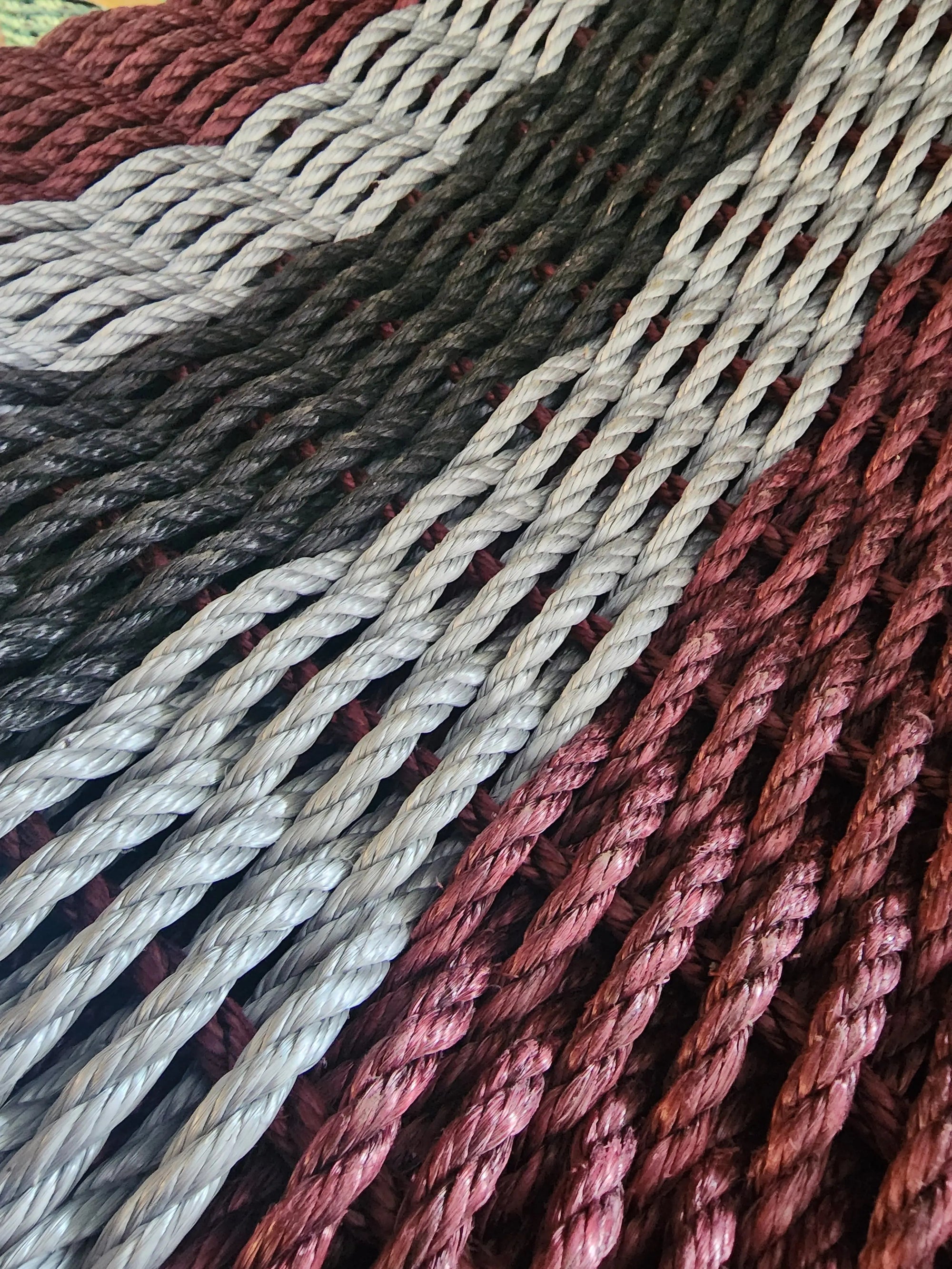 5 Stripe Lobster Rope Mat in Burgundy, Light Gray, and Black laid out on floor