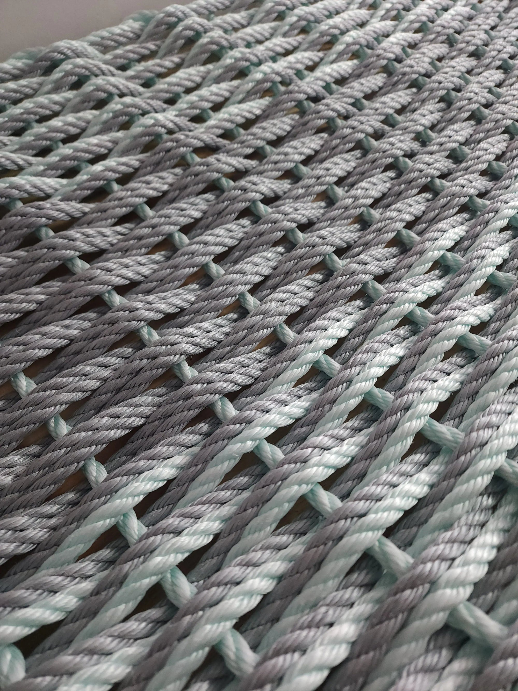 Large double weave lobster rope mat in light gray and seafoam colors