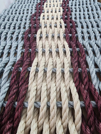 Light gray and light tan outdoor mat with burgundy accents made of polypropylene rope