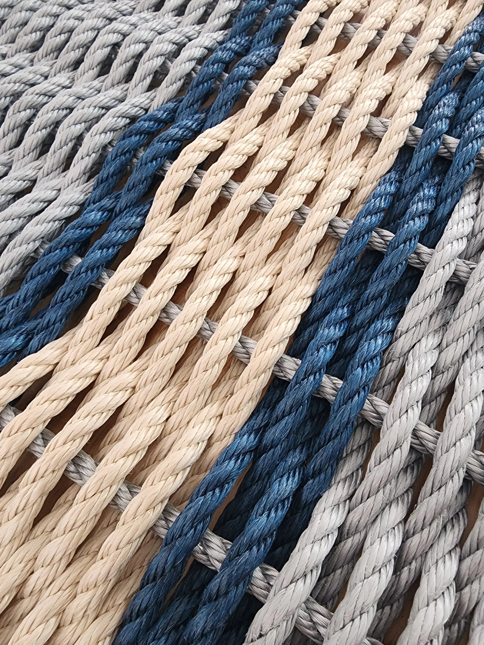 Light gray and light tan outdoor mat with navy blue accents