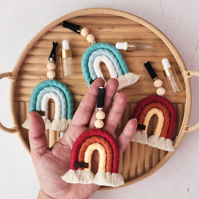 Macrame Car Vent Rainbow Diffuser hanging from a car vent in red and jade variations