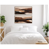 Two-piece abstract wall art with earthy brown and beige brushstrokes in wooden frames, hung above a white bedding set in a bright bedroom with plants.