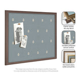 Rectangular blue pinboard with subtle white botanical pattern within a medium brown wooden frame, displaying two black-and-white photos pinned with wooden pushpins.