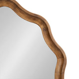 Close-up of a round mirror with a scalloped wooden frame featuring smooth curves and a warm natural finish.