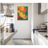 Framed canvas artwork of overlapping large citrus fruit shapes in orange, yellow, and red with green leaves, hanging on a white kitchen wall near a stone countertop.