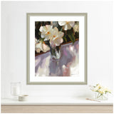 Framed painting of white flowers in a glass vase with soft shadows on a purple-hued surface, displayed above a white shelf with a small flower arrangement.