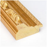 Close-up of a gold ornate picture frame corner with intricate floral and linear patterns on a white background.