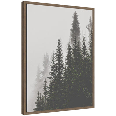 Framed canvas art showing tall pine trees emerging through thick fog in muted tones