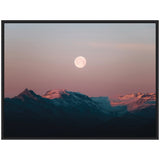 Framed canvas showing a full moon rising over Icelandic mountains with snow patches under a pastel pink and blue sky at dusk.